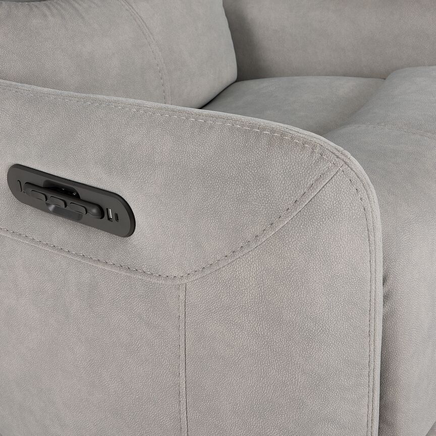 Close-up of grey Chase recliner arm showing integrated remote storage, charging ports and stitched upholstery