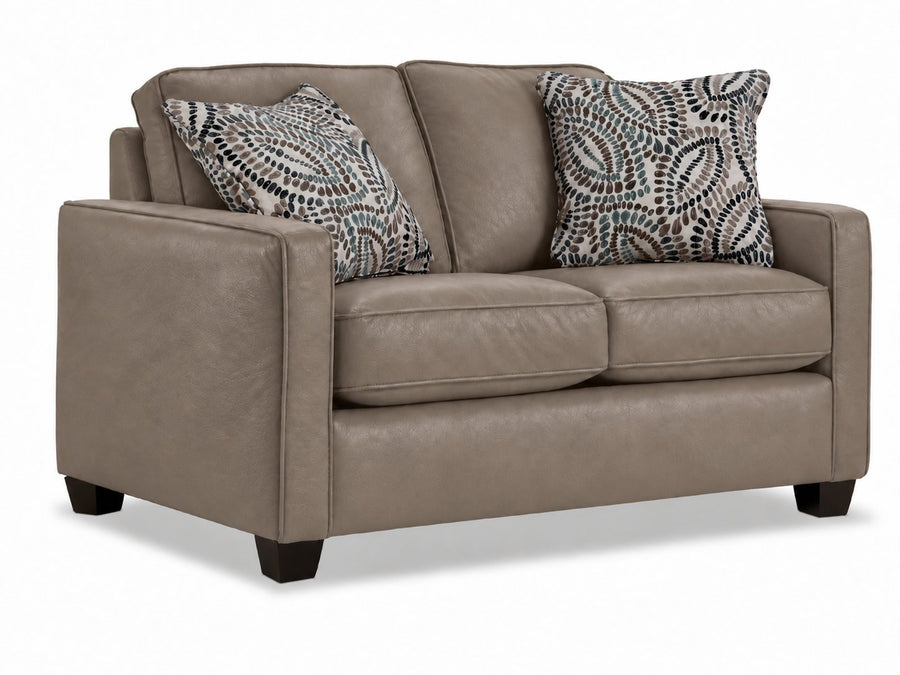 City Leather Loveseat - Stone in a three-quarter view with two cushioned seats, slim track arms, dark wood legs and two patterned accent pillows