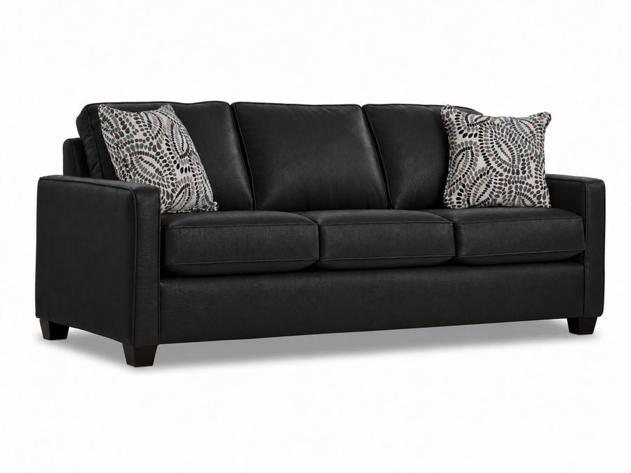City Leather Sofa - Black in a three-quarter view with three seat cushions, slim track arms, dark wood legs and two patterned accent pillows