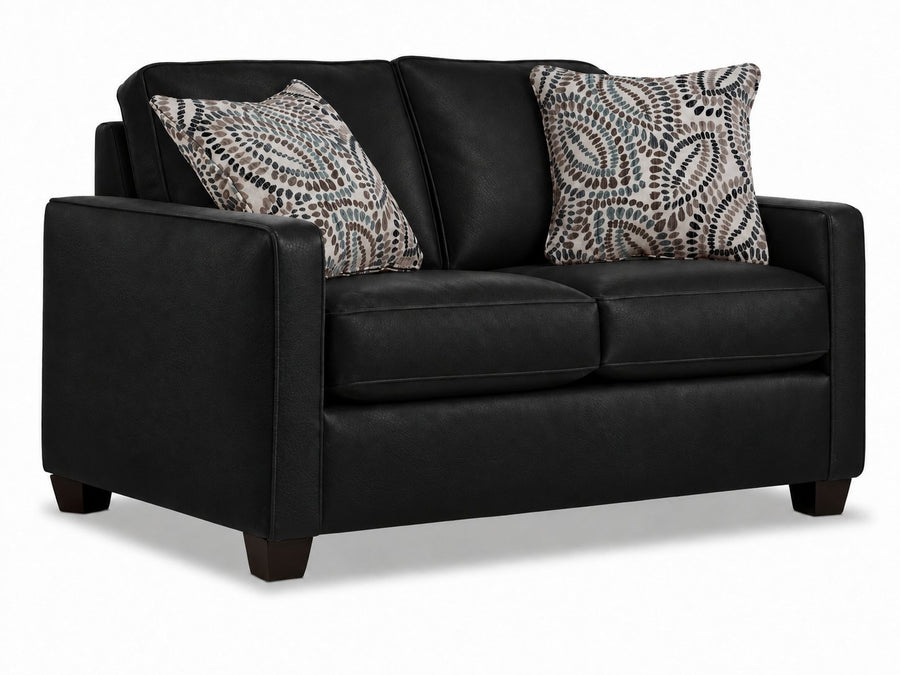City Leather Loveseat - Black in a three-quarter view with two cushioned seats, slim track arms, dark wood legs and two patterned accent pillows