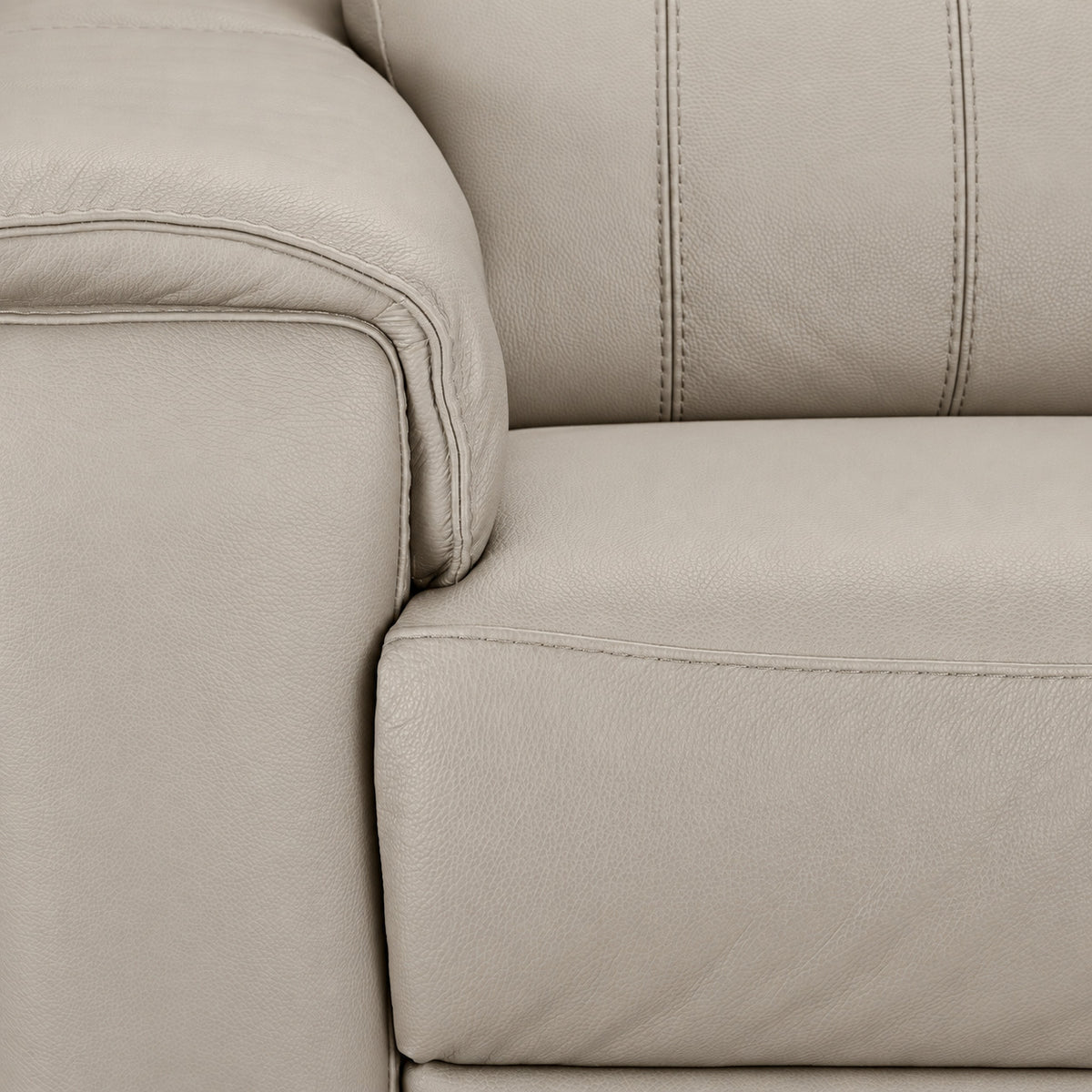 Close-up of light grey leather texture, stitching, armrest and seat cushion