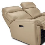 Apollo beige leather loveseat close-up showing adjustable headrests, padded arm and side-mounted power controls