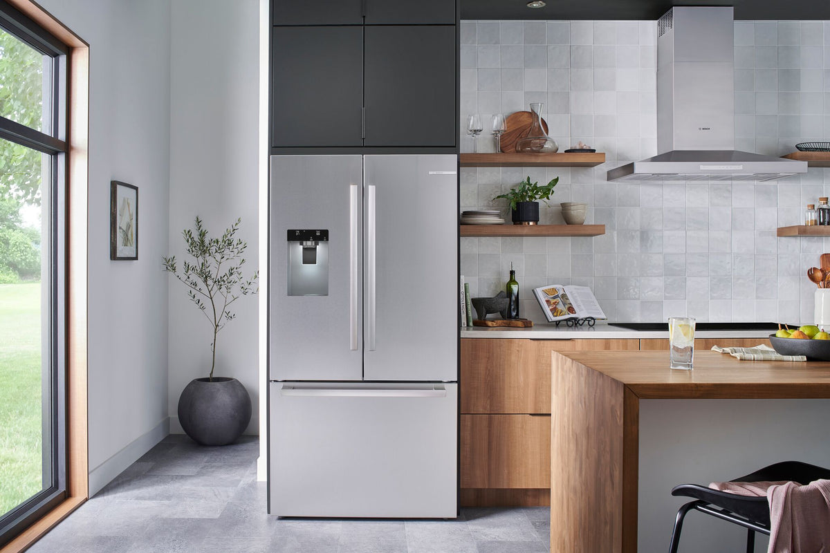 Bosch counter-depth French door refrigerator in a modern kitchen with stainless steel finish and bottom freezer drawer