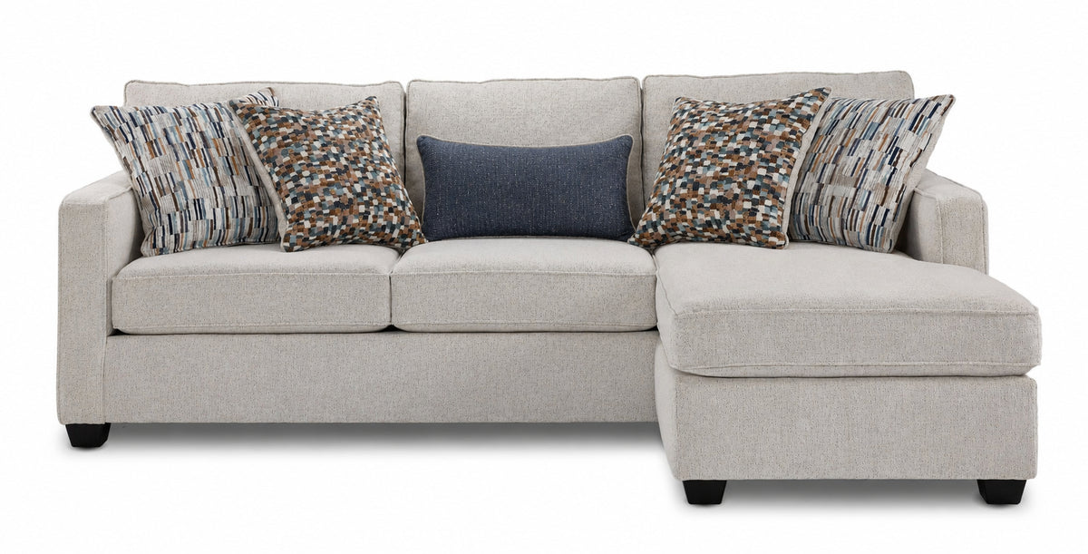 Front view of Laila beige polyester sofa chaise with patterned accent pillows and chaise positioned on the right