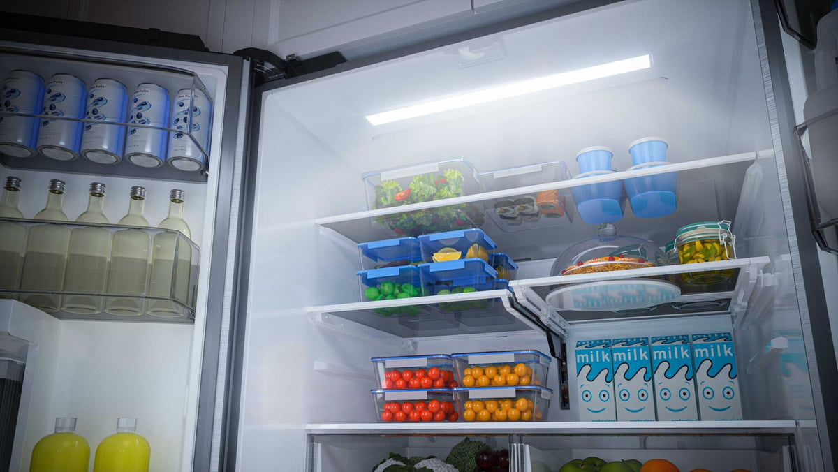 Stocked refrigerator shelves beneath bright LED interior lighting