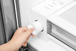 Close-up of the removable refrigerator water filter being pulled from its housing