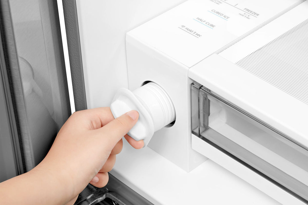 Close-up of the removable refrigerator water filter being pulled from its housing