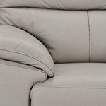 Close-up of grey leather texture, stitching, padded arm and seat cushion