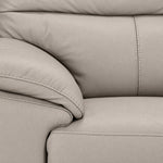 Close-up of light grey leather grain, stitching, padded arm and seat cushion