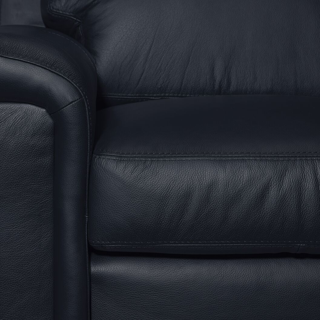 Icon Leather Loveseat - Navy close-up showing leather upholstery, stitching, padded arm and seat cushion